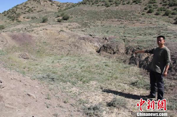 当地人介绍发现“九龙壁”化石的地方