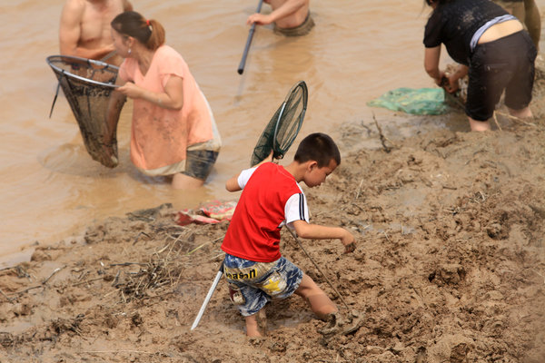 河南三门峡大坝黄河调水调沙,众多群众在黄河边捞鱼