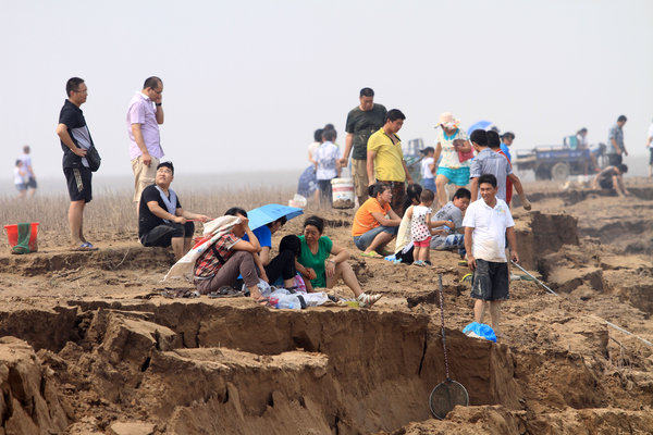 河南三门峡大坝黄河调水调沙,众多群众在黄河边捞鱼