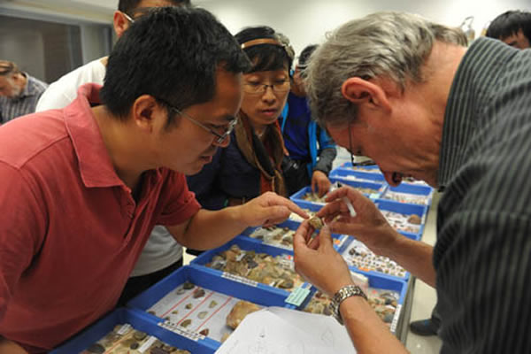 法国专家(J. Jaubert)认真查看石器标本并与侯亚梅和刘扬交流看法