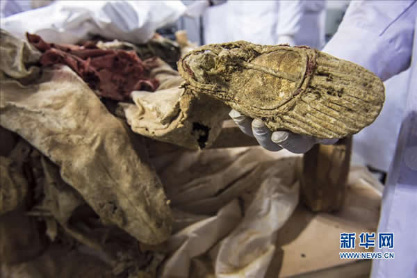 11月20日,来自中国丝绸博物馆、吐鲁番学研究院与吉林省博物院的多位考古专家小心翼翼地揭取古干尸身上的衣物。