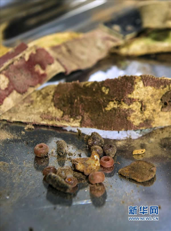 11月20日,来自中国丝绸博物馆、吐鲁番学研究院与吉林省博物院的多位考古专家小心翼翼地揭取古干尸身上的衣物。