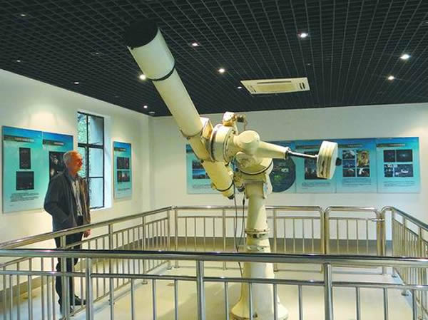 紫金山陈列馆中,澳大利亚天文学家正在聚精会神地观看我国25cm口径天文望远镜。