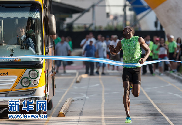 12月14日,博尔特(右)冲过终点线。当日,在阿根廷布宜诺斯艾利斯市中心七九大道上,牙买加短跑名将博尔特与公交车进行80米赛跑,引来众多市民围观。博尔特此次造访