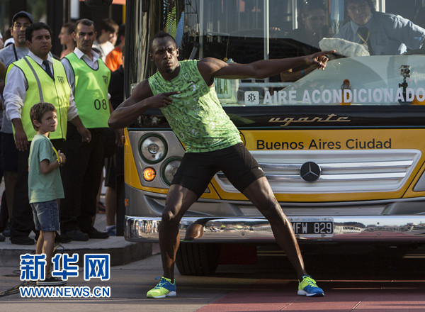 12月14日,博尔特(前)在公交车前摆出其标志性庆祝动作。