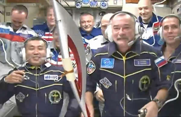 俄罗斯宇航员米哈伊尔·秋林在远征37-38任务中手持奥运火炬的情景。