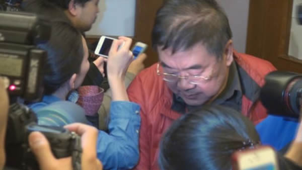 马航MH370失联后,大批大陆籍旅客家属在北京丽都饭店等待消息,一名家属神情木然地走出休息处。