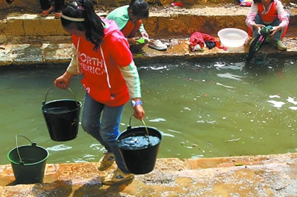 女孩儿们在村边池塘洗衣服,之后打水带到学校冲厕所。