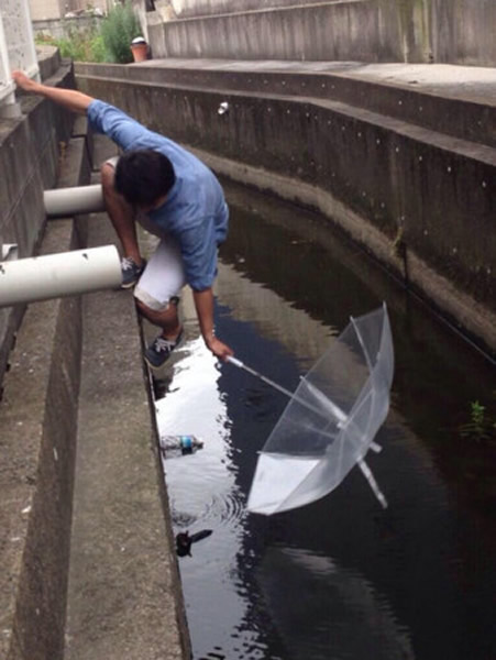 日本好心男子冒险用伞捞出落水小猫