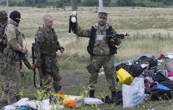 马航MH17班机遭飞弹击落,失事现场遍布旅客的行李,一名士兵还发现小孩的布偶。