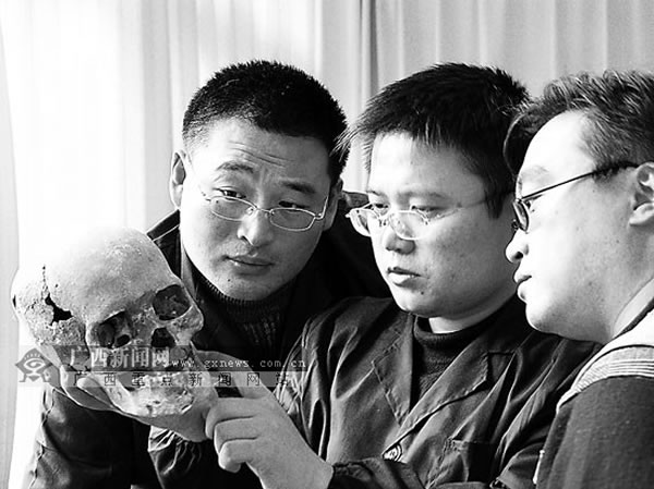 考古人员在研究甑皮岩人头骨
