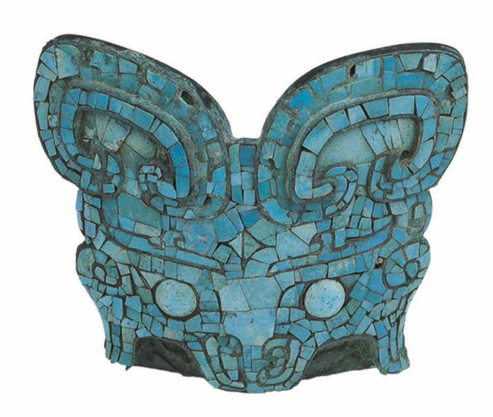 「镶嵌绿松石兽面饰」出土于马坑,推测应是马冠饰。以青铜为底,先铸出兽面图案的轮廓线,再切割绿松石,镶嵌上去;器物背面有两梁交叉,呈X形,可用来穿系皮革。图片提供
