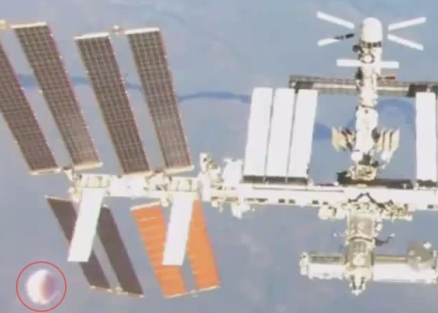 一个银白色的圆形不明飞行物体(红圈示),在国际太空站附近出现。