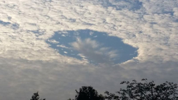 深圳南山区更有人摄得“鸳鸯云”如白云中间出现一圆洞。