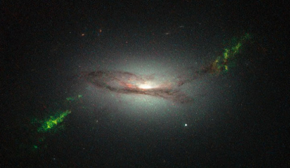 哈勃望远镜拍摄的图像显示,绿色光芒就像是星系碰撞后留下的痕迹,实则为超级黑洞的辐射爆炸所致。