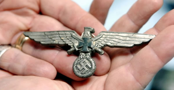 令人意外的是,波兰人在剖开鱼腹后发现德国纳粹时期的金属材质的军章。