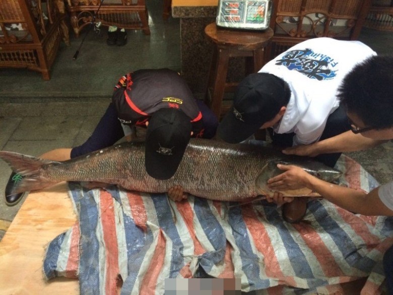 两人需合力才能把大鱼抬起