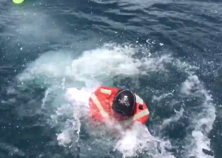 翻艇后,钱斯立即游回另一船上。