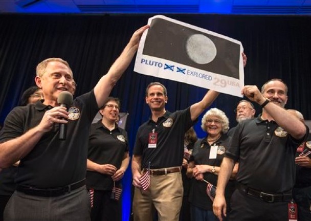 科学家高举冥王星照片