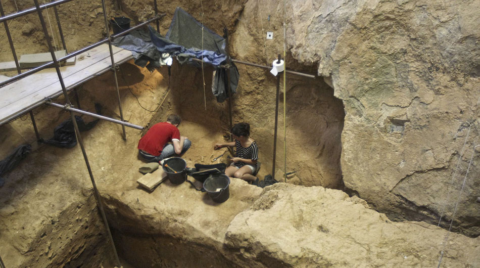 考古志愿者们在托塔韦山洞考古遗址中工作