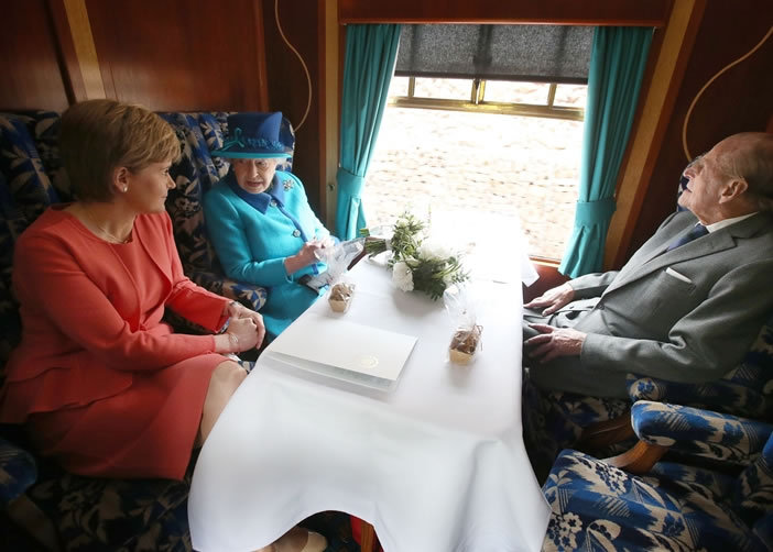 英女王(中)与斯特金(左)交谈,对面是丈夫菲腊亲王。