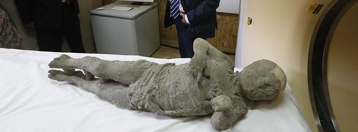 这具男孩遗体是在一名成年男性和一名成年女性身边发现的,他们可能是男孩的父母。此外,女子膝盖上还有一个熟睡的小男孩。