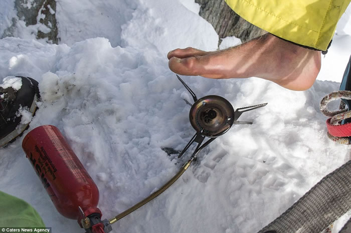 挑战前,他用小火炉给脚底保暖。