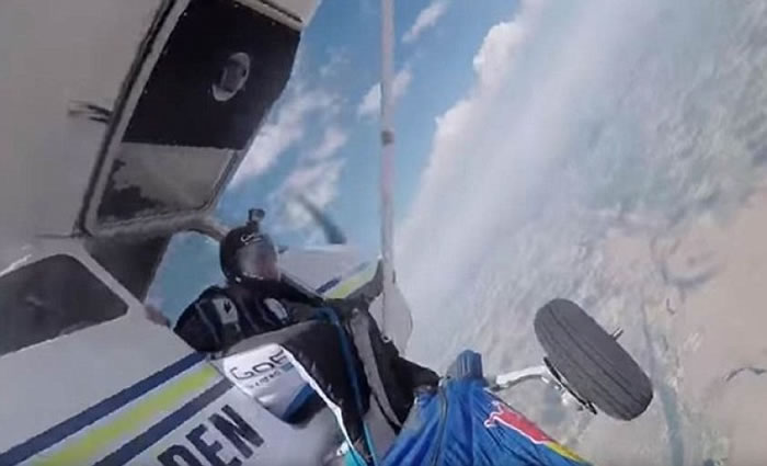 旁人协助他解开卡着的跳伞装。