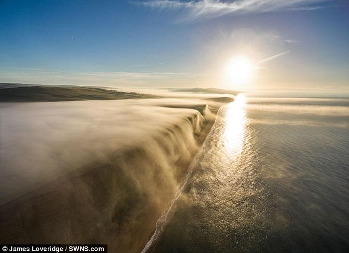 英国多塞特郡西湾出现奇特自然现象 一片白雾在崖边如瀑布向下飞泻