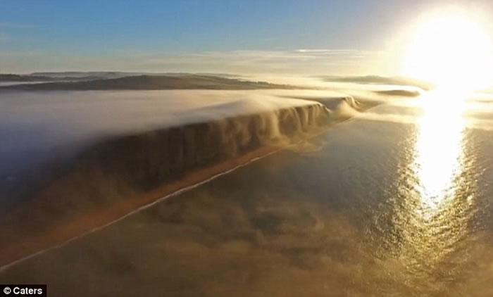 英国多塞特郡西湾出现奇特自然现象 一片白雾在崖边如瀑布向下飞泻