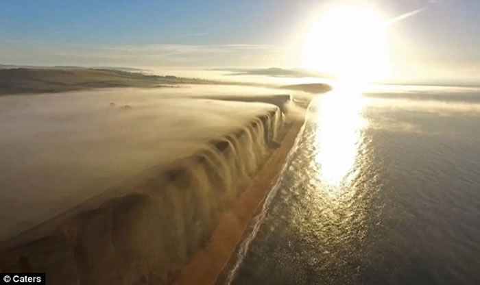 英国多塞特郡西湾出现奇特自然现象 一片白雾在崖边如瀑布向下飞泻