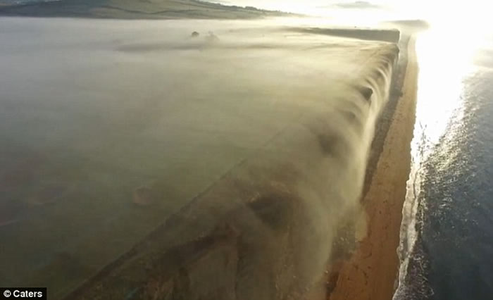 英国多塞特郡西湾出现奇特自然现象 一片白雾在崖边如瀑布向下飞泻