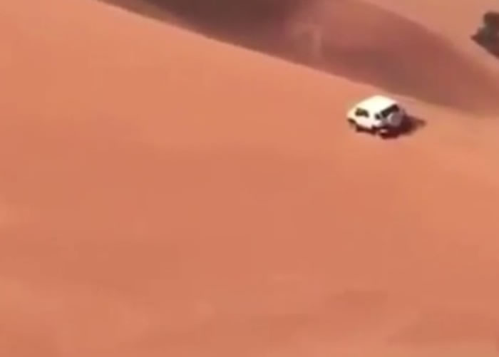 越野车驶向沙丘顶部。