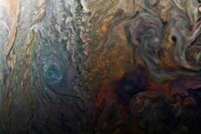 这幅朱诺号色彩强化的影像,显现出木星上神秘的黑斑。 PHOTOGRAPH BY NASA