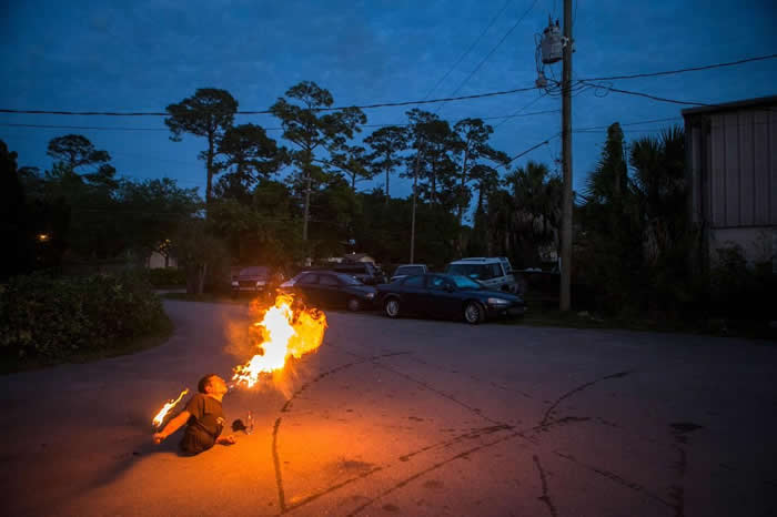 艾伦.沃林在自家后院的停车场,为了马戏团的演出练习喷火。 「我想要在40年后成为传奇,」沃林说道:「变成人们的话题焦点。」PHOTOGRAPH BY BRIAN