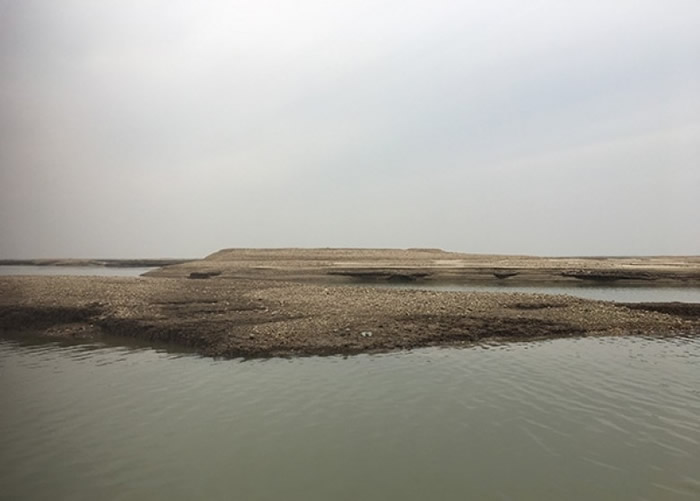 枯水期时露出水面的不长草的尾堆。