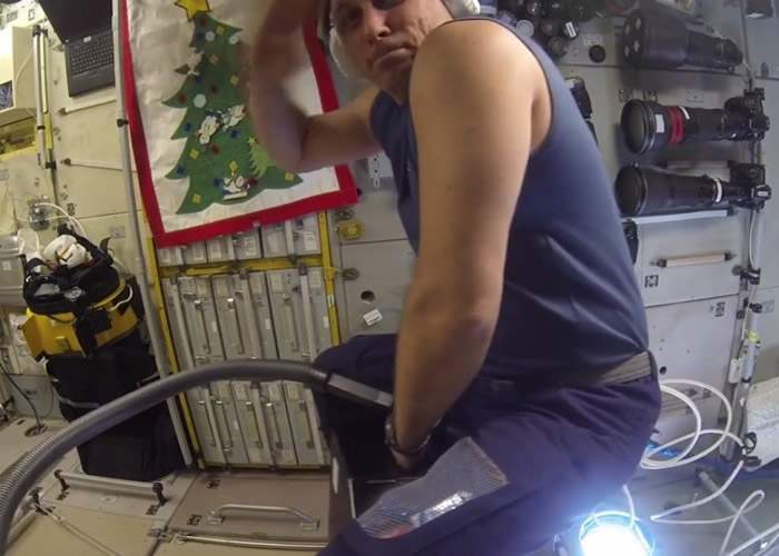 希卡普罗夫骑在吸尘机上向观众敬礼。