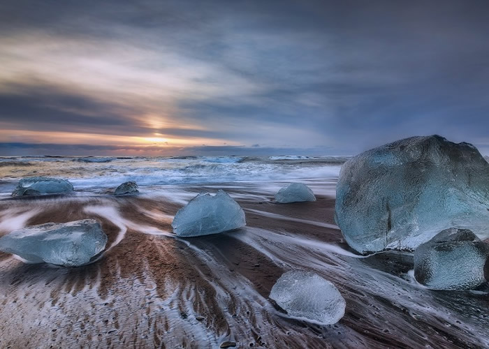 随冰川瓦解崩塌下来的冰块,在海浪冲刷下显得白净剔透。