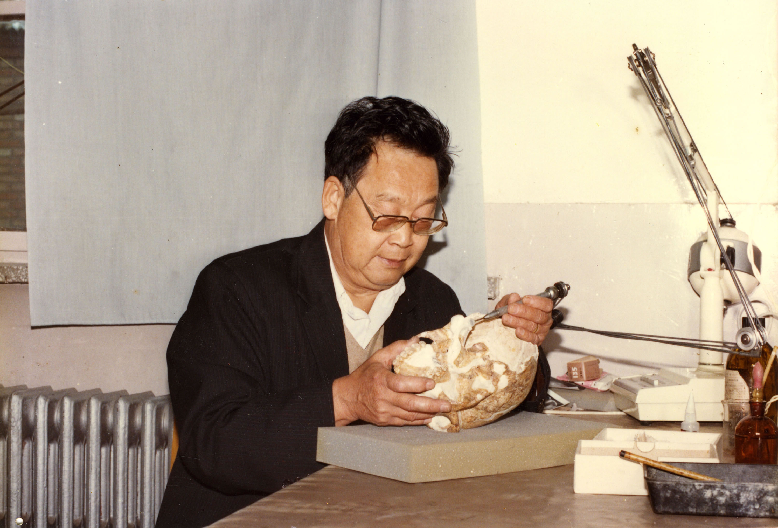 吕遵谔教授进行金牛山人头骨的研究工作