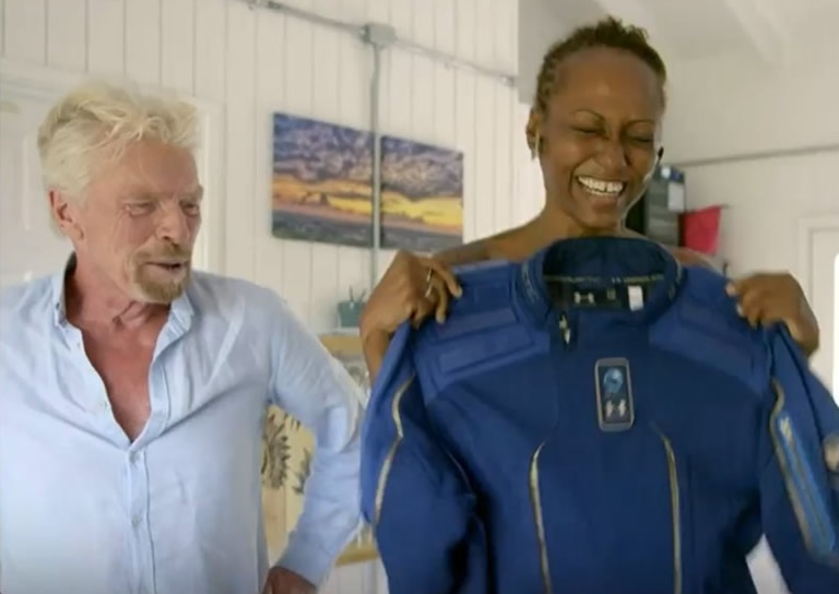 布兰森(左)将太空衣送上给沙哈夫(右)